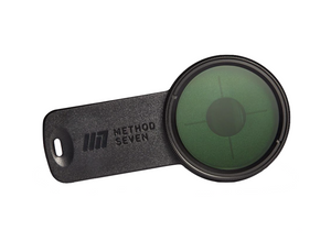Method Seven Catalyst Blurple LED Phone & Tablet Camera Filter. Black in colour with a high-quality Carl Zeiss lens for insane optical clarity when used under purple, blurple, or magenta spectrum LED grow lights. The lense has a greenish colour to it and the clip is rectangular in shape, black in colour. 